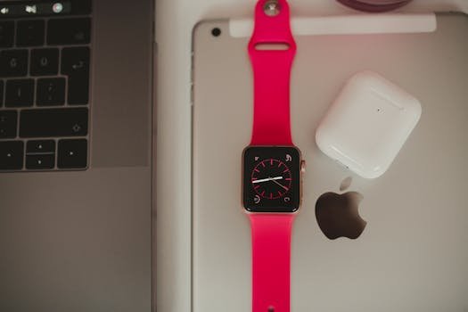 Home Close-up of a smartwatch, laptop, and earbuds showcasing sleek modern technology.