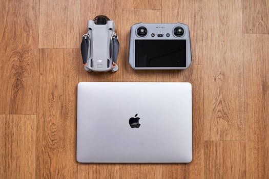 Home Overhead shot of a drone, controller, and laptop on a wooden floor