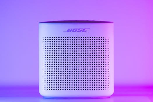 Home A sleek, modern Bluetooth speaker with a purple and blue light gradient, perfect for home audio setups.